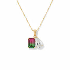 Gold necklace with two gemstone pendants on a gray background