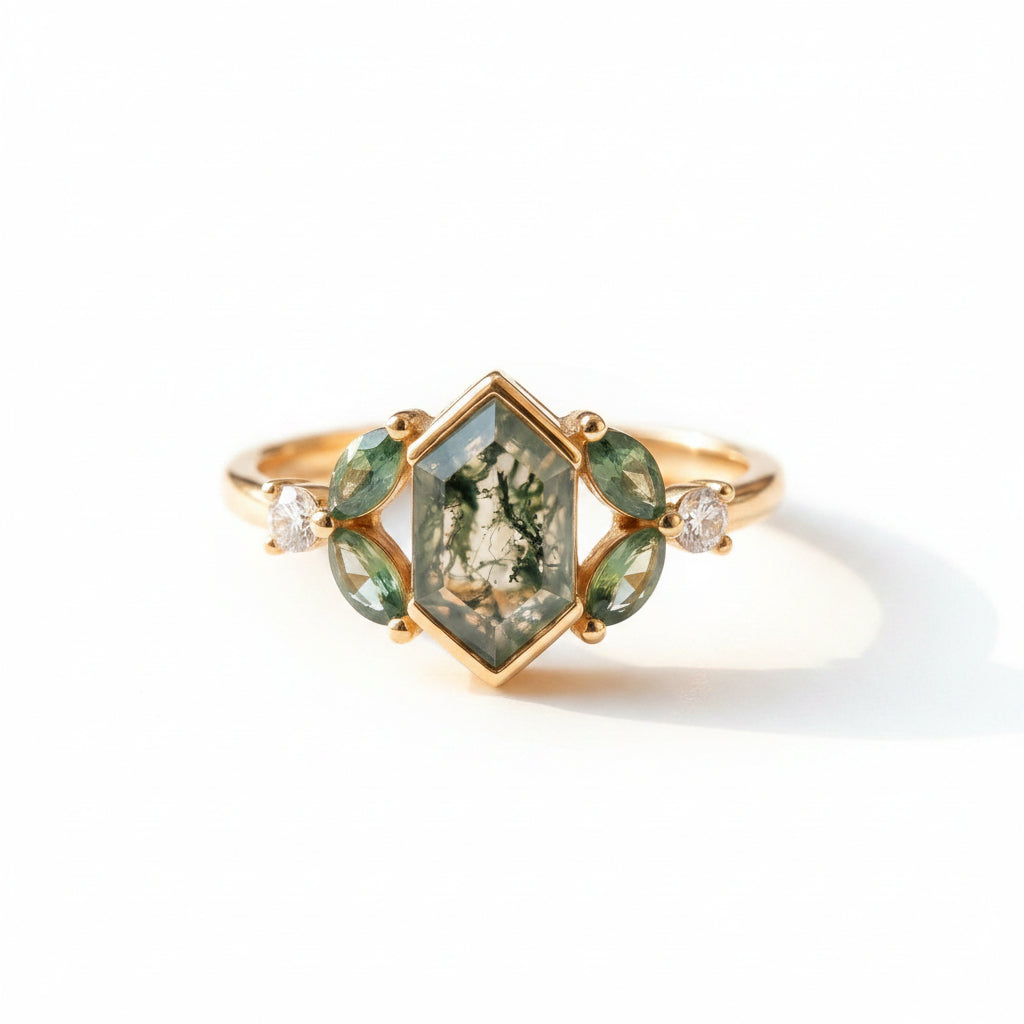 Gold ring with green gemstones on a textured fabric background