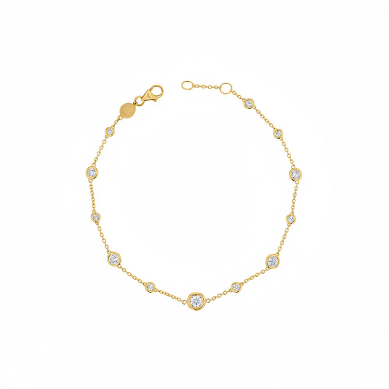 A delicate gold chain bracelet featuring multiple bezel-set round clear stones, displayed on a white background with a faint diagonal watermark pattern.