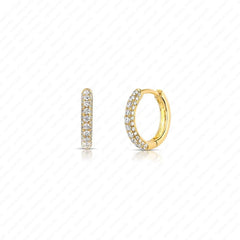 A pair of gold huggie hoop earrings adorned with pavé-set clear stones, shown from two angles on a white background with a faint diagonal grid pattern.