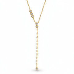 A gold Y-shaped necklace with three clear round-cut gemstones on the upper chain and one dangling gemstone at the bottom, shown on a white background with a faint diagonal watermark pattern.