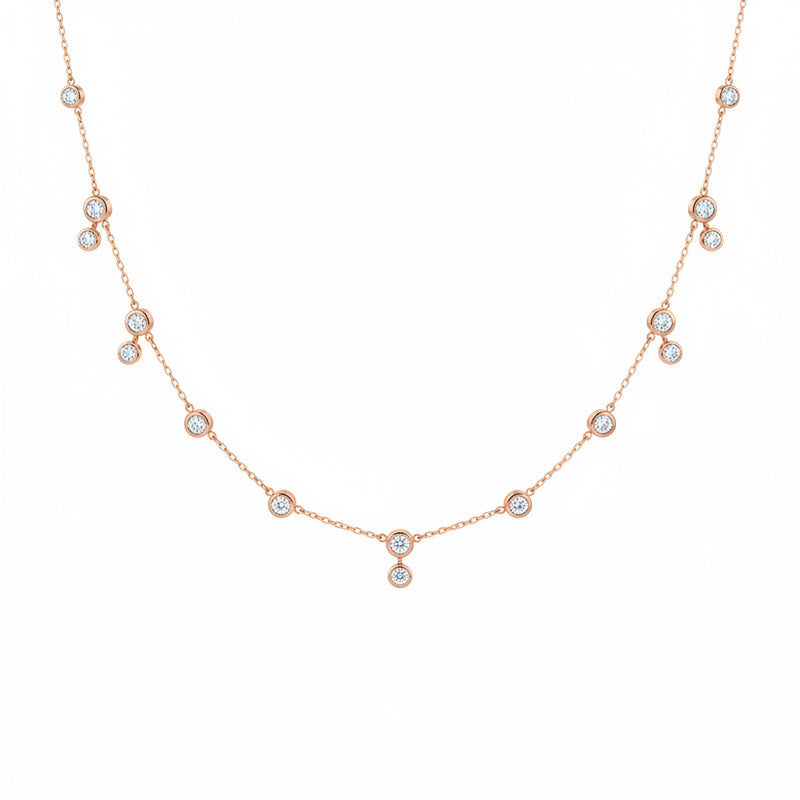 A delicate rose gold chain necklace featuring multiple small round bezel-set clear stones spaced along the chain, displayed against a white background with a faint diagonal watermark pattern.