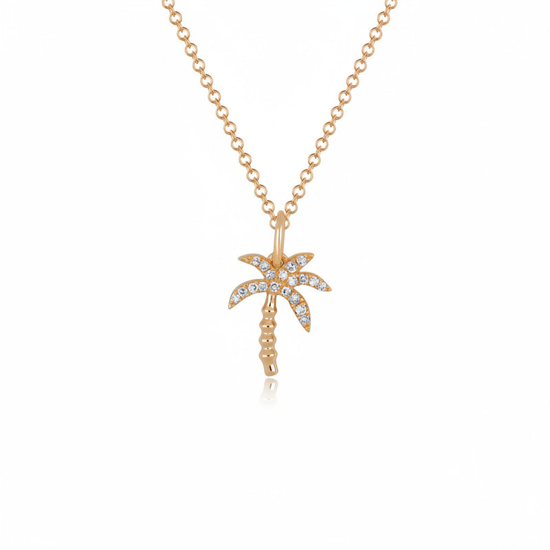 A gold-toned necklace with a palm tree pendant adorned with small clear stones, shown on a white background with a faint repeating watermark.