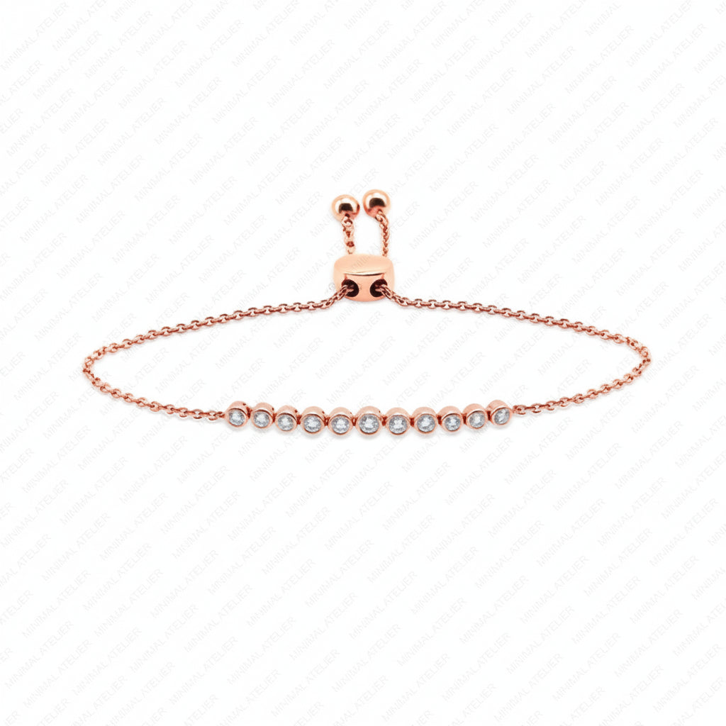A delicate rose gold chain bracelet with a central row of small clear gemstones, displayed on a white background with a faint diagonal watermark pattern.