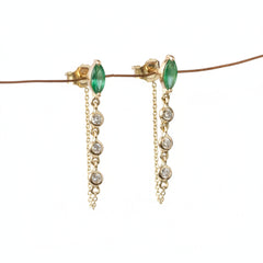 A pair of gold dangle earrings with marquise-cut green gemstones and clear round stones on a chain, displayed against a white background with a diagonal watermark pattern.