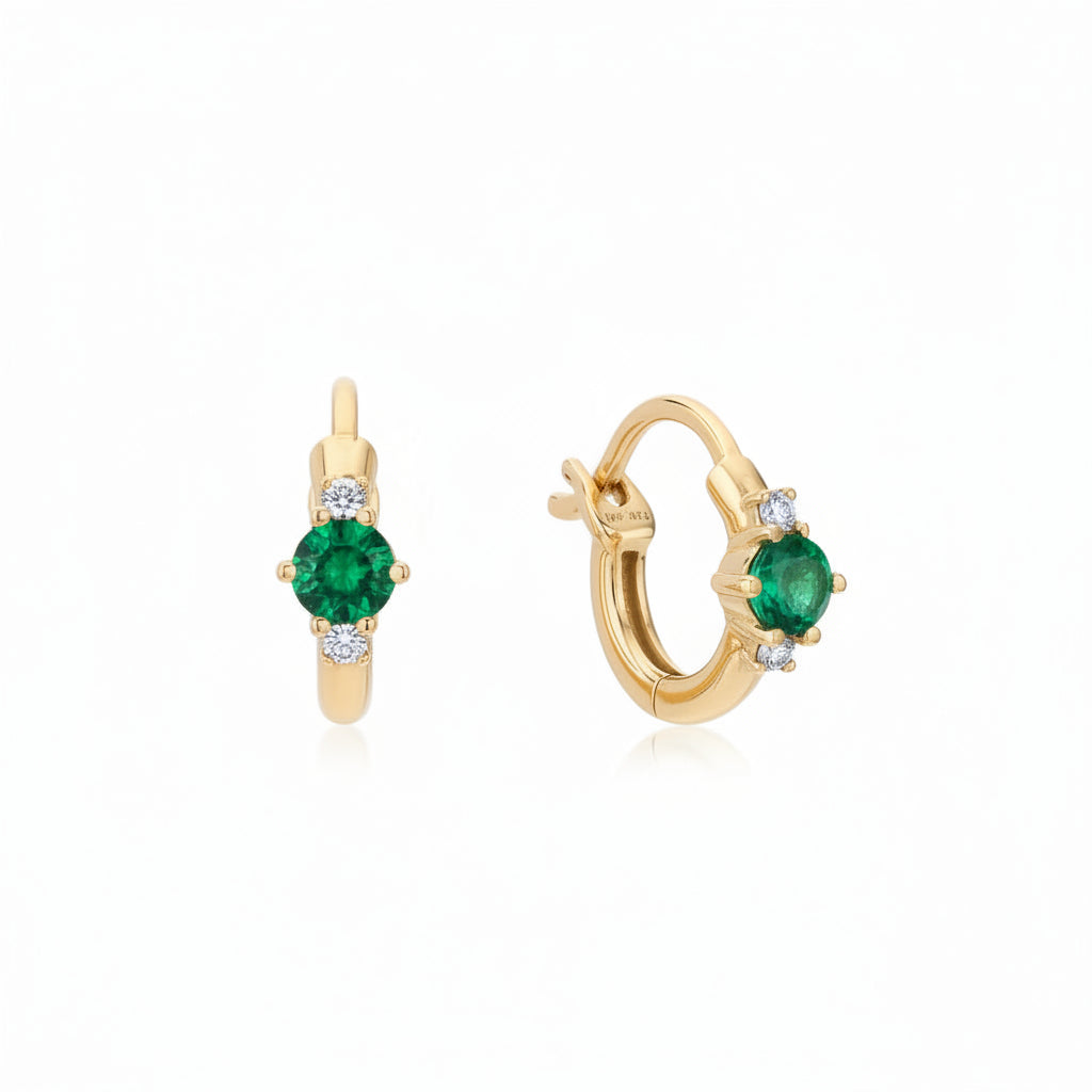 A pair of gold huggie hoop earrings with round green emerald-cut center stones and small clear accent stones, shown on a white background with a faint diagonal watermark pattern.