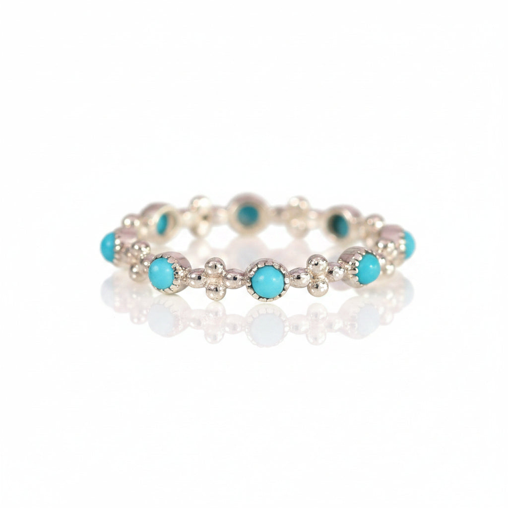 A silver-toned beaded bracelet featuring round turquoise blue-green cabochon stones, displayed on a light pink background with a repeating 'MINIMAL ATELE' watermark pattern.
