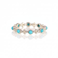 A silver-toned beaded bracelet featuring round turquoise blue-green cabochon stones, displayed on a light pink background with a repeating 'MINIMAL ATELE' watermark pattern.