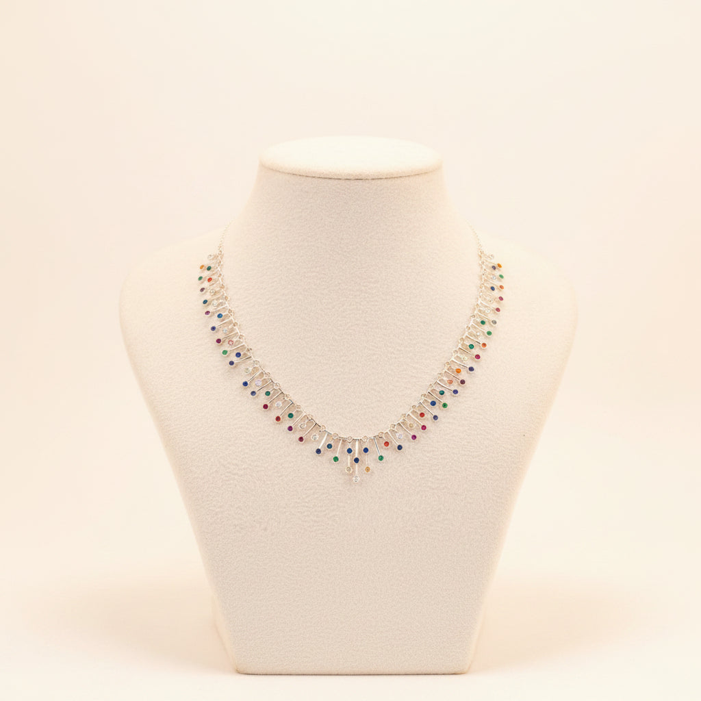 A silver-toned statement necklace with multiple dangling colorful gemstone clusters, displayed on a white fabric mannequin bust against a gray background.