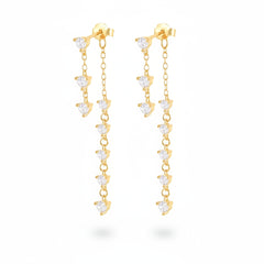 A pair of gold dangle earrings with clear heart-shaped crystals, displayed on a white background with a repeating watermark.