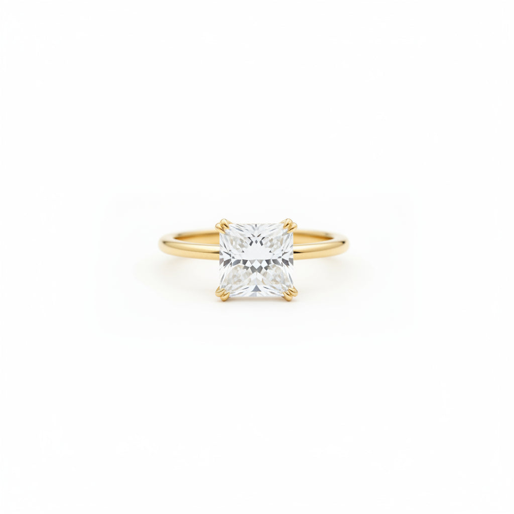 A yellow gold ring with a large princess-cut clear gemstone resting on a rustic wooden book next to a cream lace cloth.