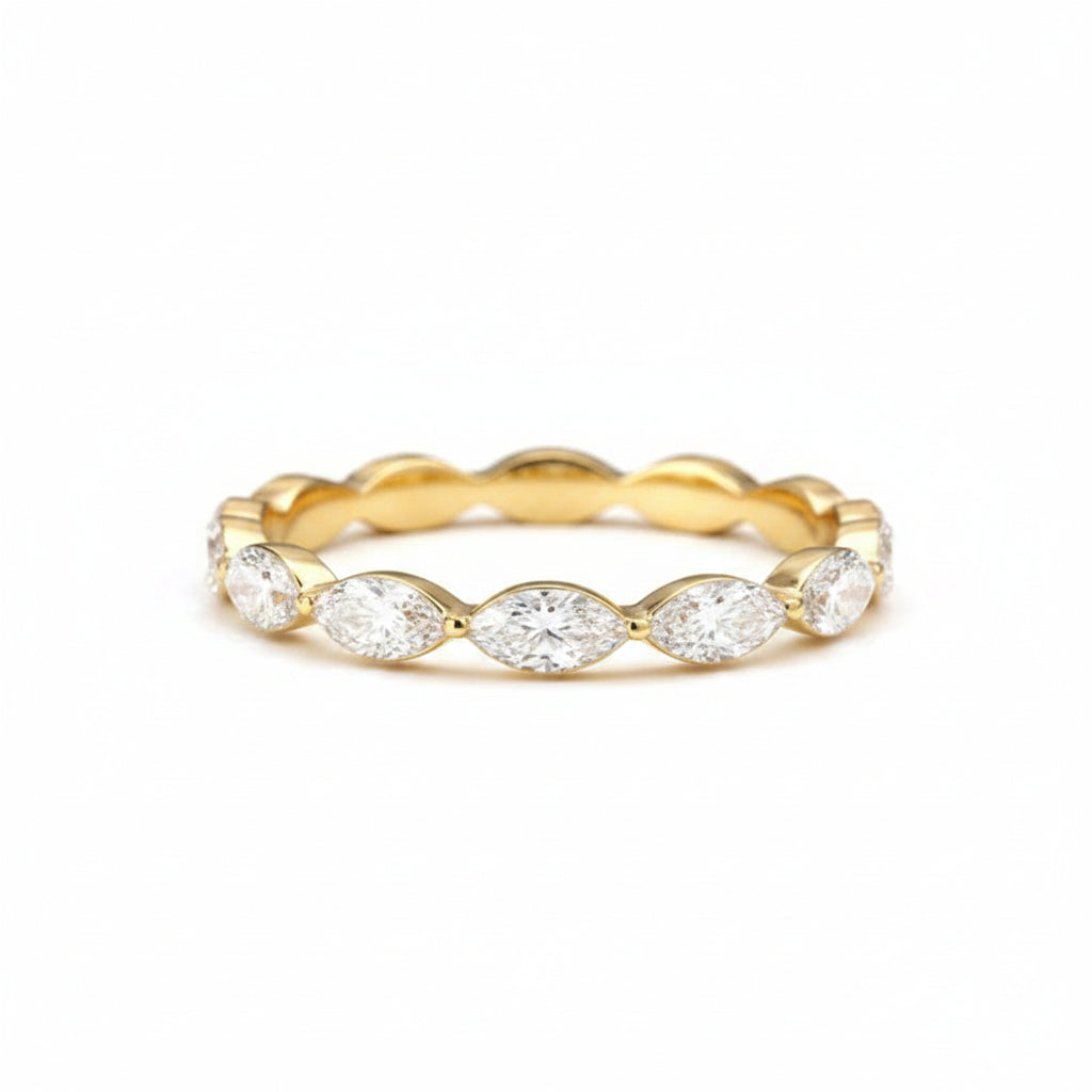 Gold ring with marquise-shaped diamonds on a soft beige fabric background
