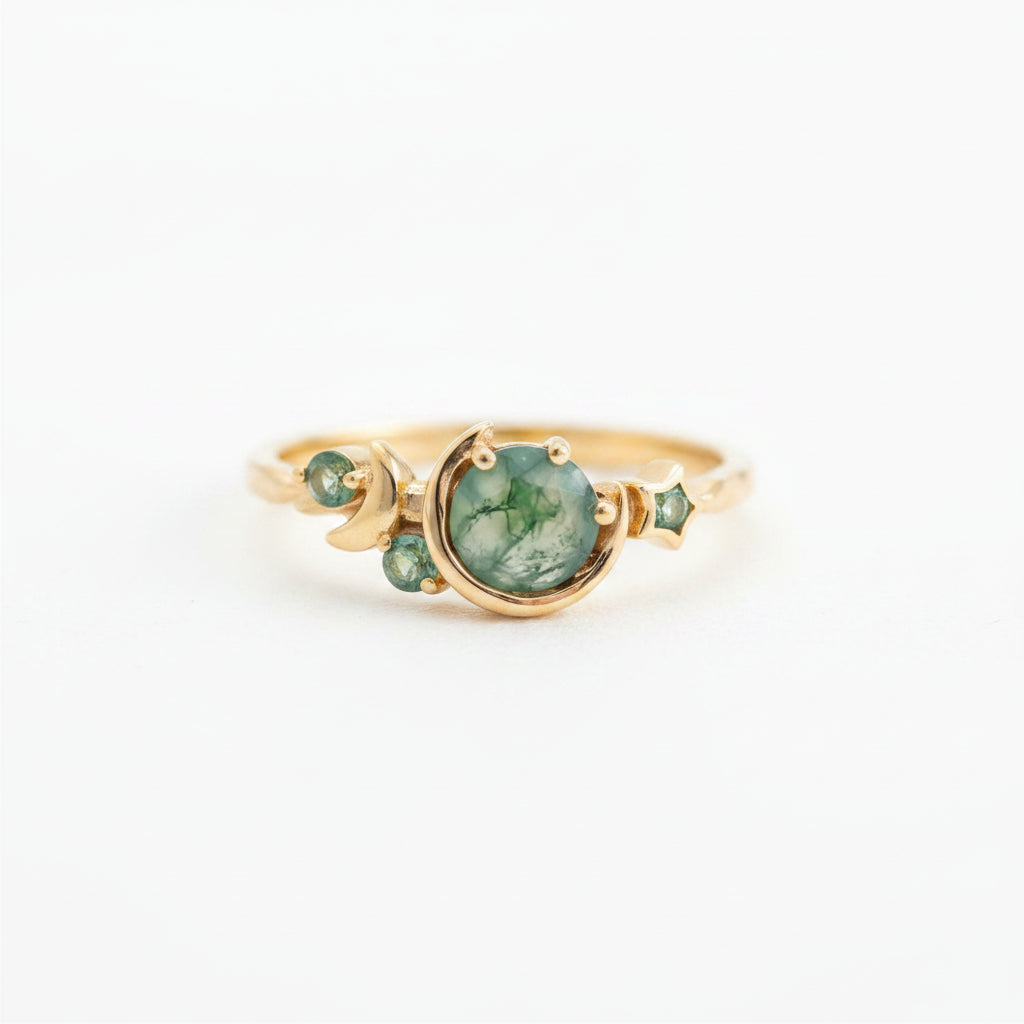 A gold ring with a large green stone and smaller green stones, displayed on a lace cloth over an old book on a wooden surface.