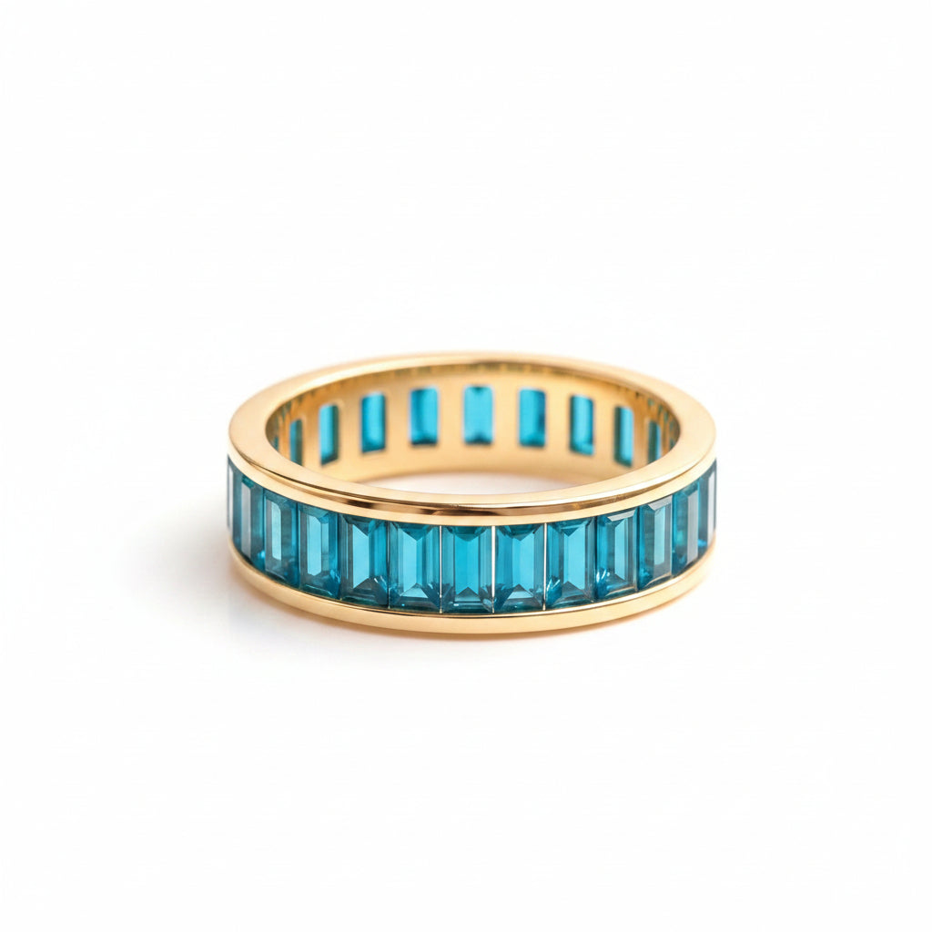 Gold ring with blue gemstones on a textured surface