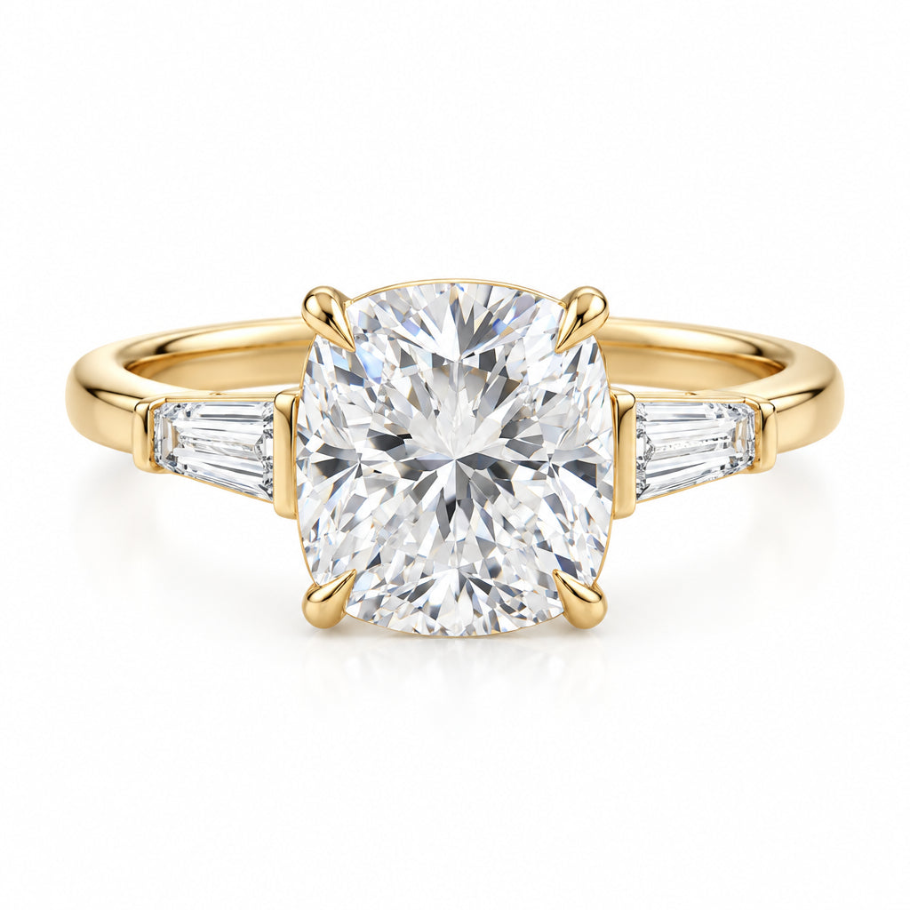 A yellow gold engagement ring featuring a large cushion-cut diamond center stone and baguette side stones, resting on a textured cream lace fabric with soft green leaves blurred in the background.