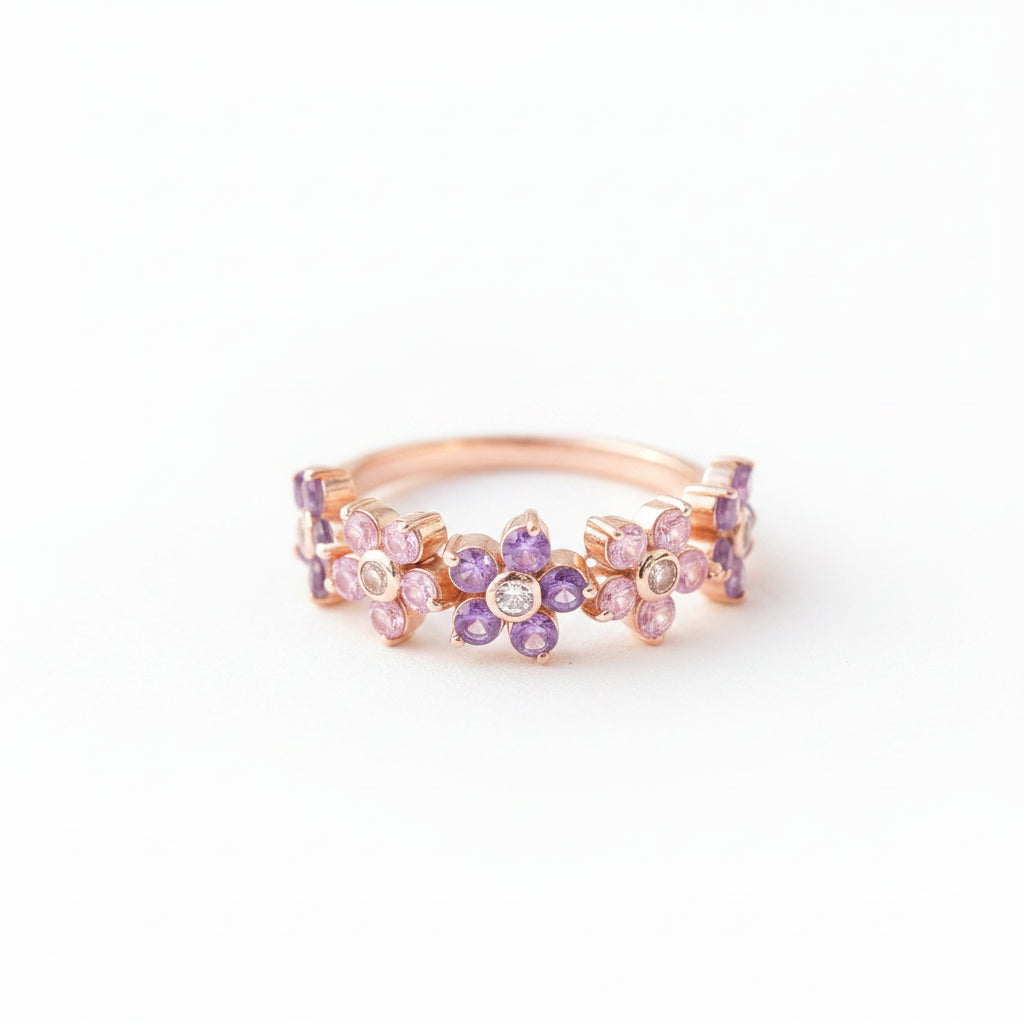 Rose gold ring with colorful gemstones on a textured fabric background