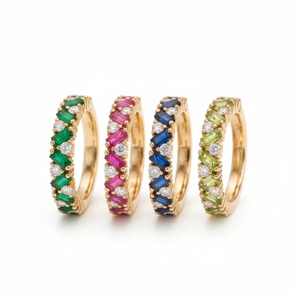 Gold hoop earrings with colorful gemstones on a textured surface with green leaves in the background