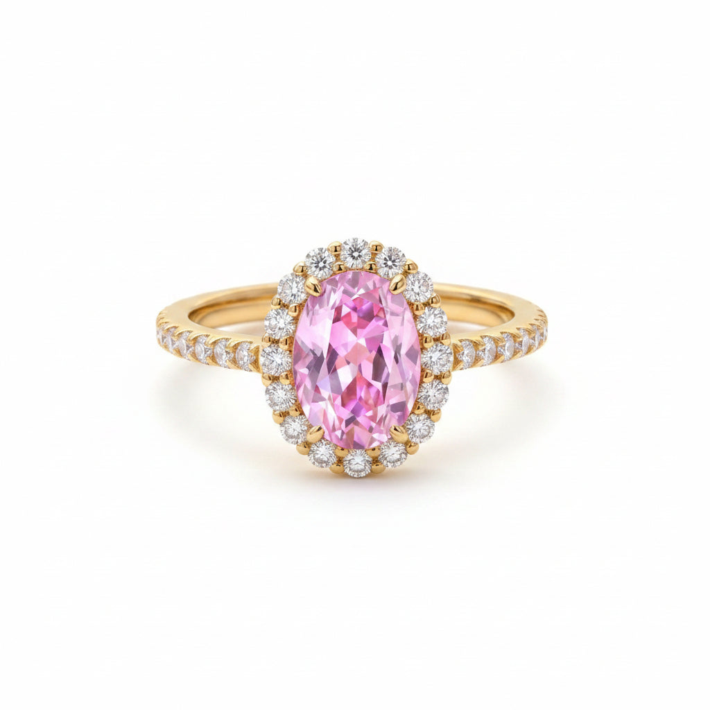 Gold ring with a pink gemstone on a textured fabric background