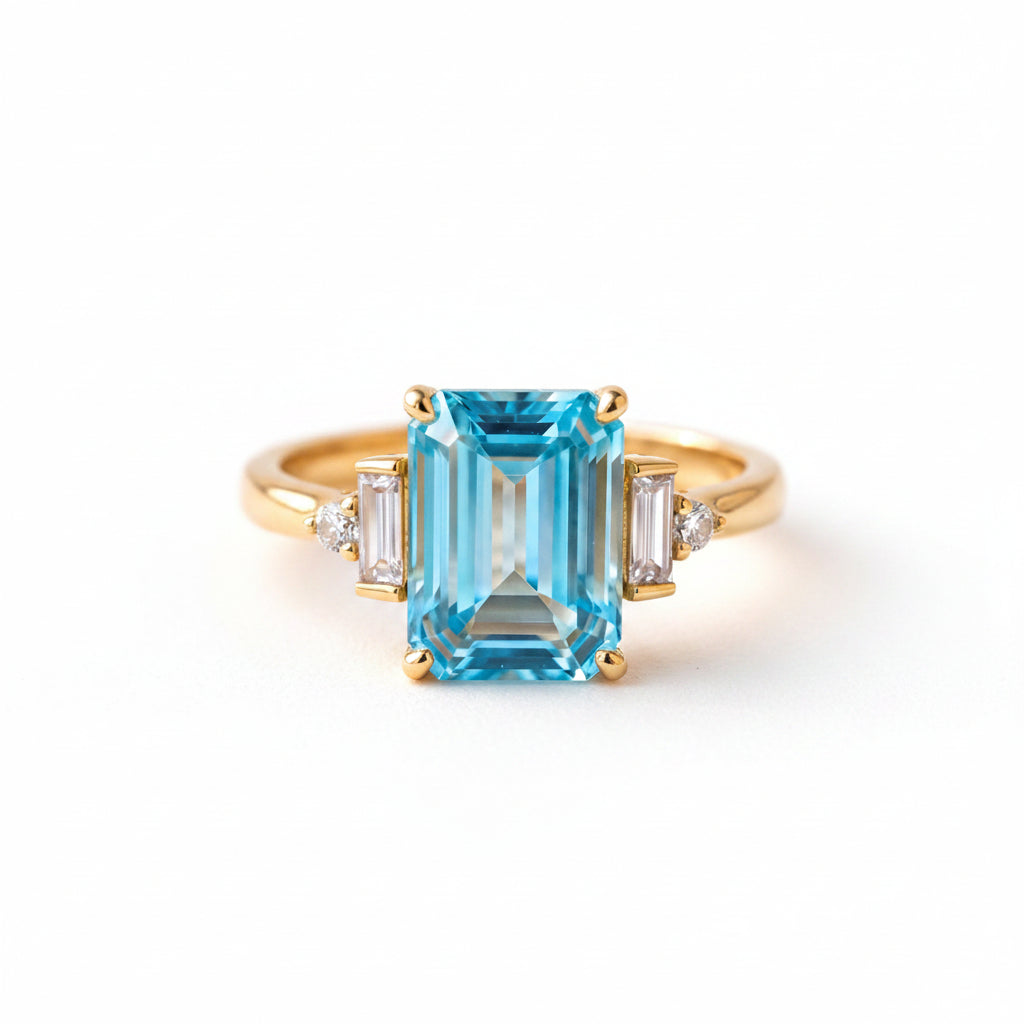 Gold ring with a blue gemstone on a textured fabric background