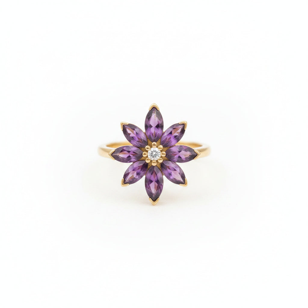 Purple flower-shaped jewelry piece on a textured fabric background with dried flowers.