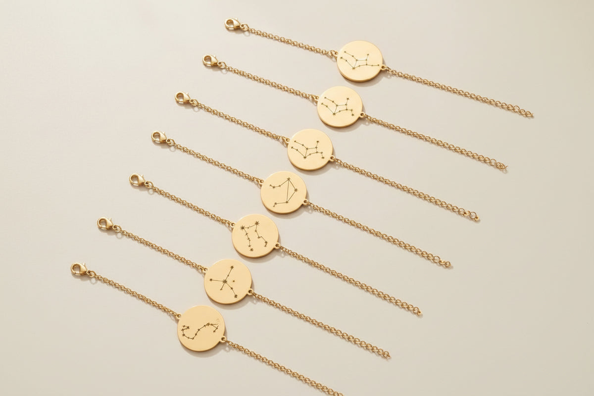 Gold bracelets with zodiac symbols on a beige background