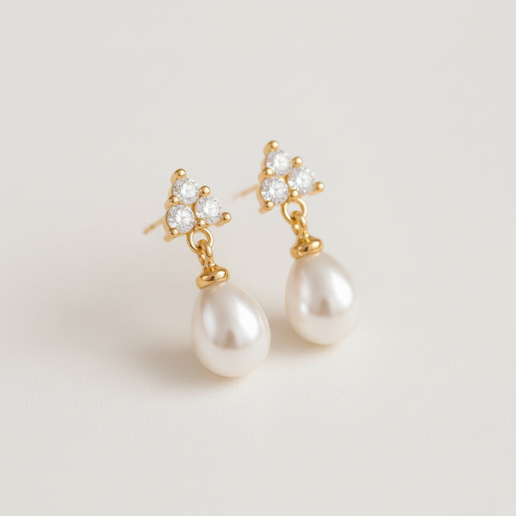 Pearl earrings with gold accents on a beige fabric background