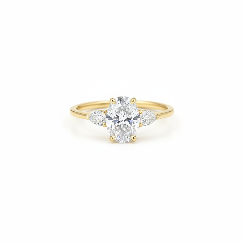 A yellow gold ring with a central oval diamond and marquise-cut side stones, displayed on a black marble pedestal against a dark background.