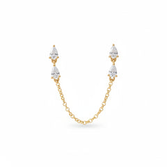 A pair of gold drop earrings with pear-cut clear stones and a connecting chain, presented in an open blue velvet jewelry box with the brand name AURORA FINE JEWELRY visible inside.