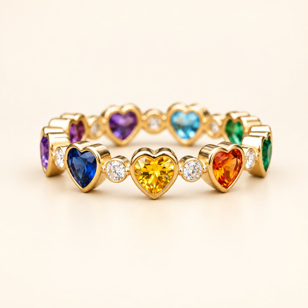 A gold heart-link stretch bracelet featuring multiple colorful heart-shaped gemstones (blue, purple, yellow, orange, green, and light blue) with small clear accent stones, displayed on a rustic wooden surface.
