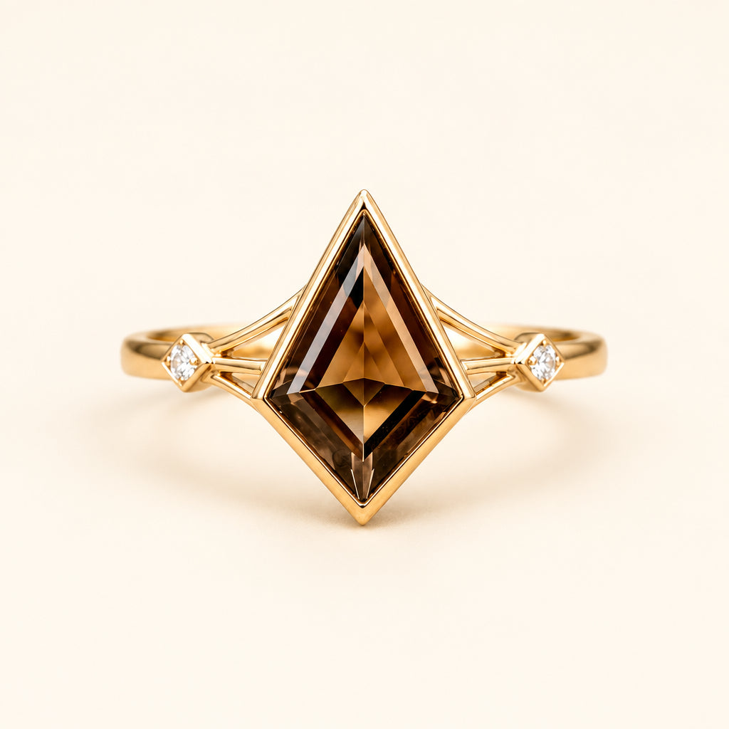A gold ring with a large diamond-cut brown gemstone and small clear accent stones on either side, photographed resting on a textured stone surface with a blurred natural background. Faint GoldGemsGlitter watermarks are visible across the image.
